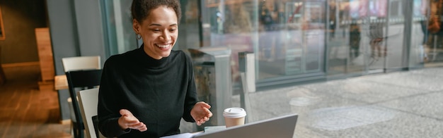 Freiberufliche Architektin, die per Videoanruf mit dem Kunden spricht und das Projekt im Café bespricht