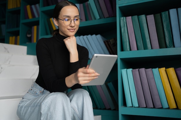 Freiberufliche Designerin, eine Frau mit Brille arbeitet in einem modernen Büro, surft im Internet