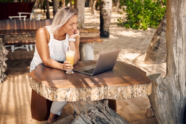 Freiberufliche Frau Arbeit von Laptop in Tropical Cafe