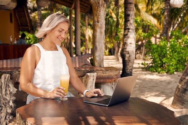 Freiberufliche Frau Arbeit von Laptop in Tropical Cafe