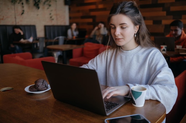 Freiberufliche Frau, die gerne aus der Ferne in einem Café arbeitet