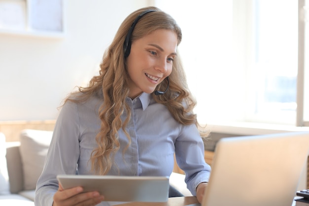 Freiberufliche Geschäftsfrauen, die Tablet-Videokonferenzen mit Kunden am Arbeitsplatz zu Hause verwenden.