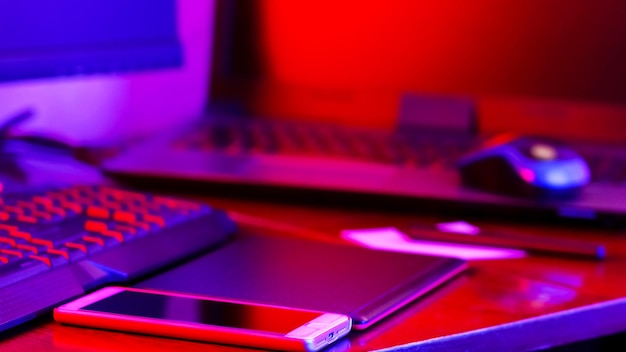 Freiberuflicher Arbeitsplatz im Neonlicht Computergrafik-Tablet und Smartphone auf dem Tisch