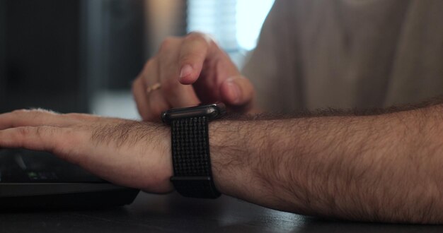 Freiberuflicher Mann mit intelligenten Uhren Browsen von Benachrichtigungen und Nachrichten Smartwatch Touchscreen