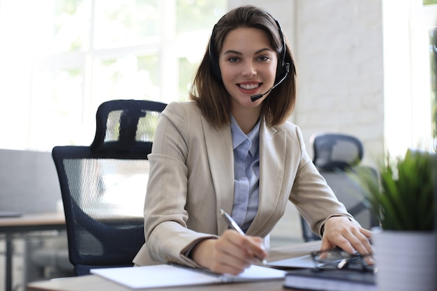 Freiberuflicher Operator, der mit Headsets spricht und Kunden aus dem Büro berät.