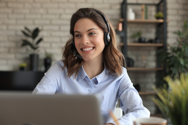 Freiberuflicher Operator, der mit Headsets spricht und Kunden aus dem Home-Office berät.