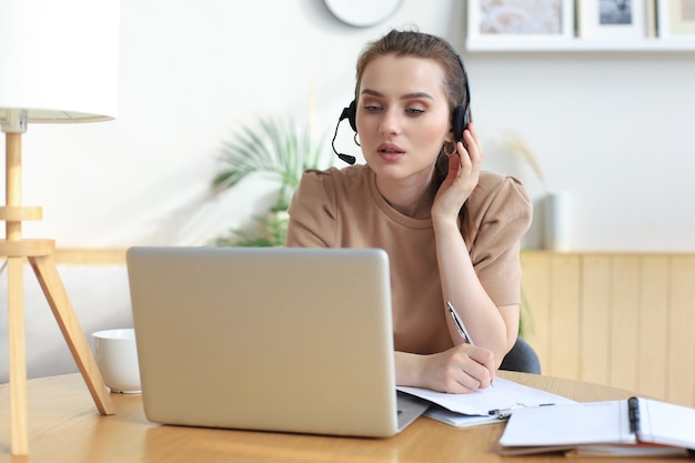 Freiberuflicher Operator, der mit Headsets spricht und Kunden aus dem Home-Office berät.