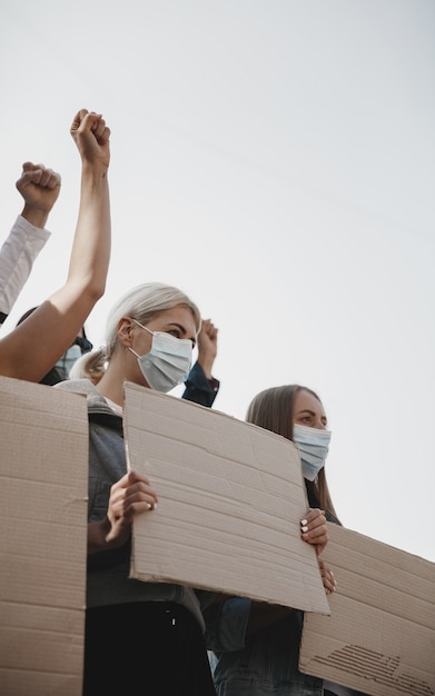 Freiheit. Gruppe von Aktivisten, die bei einer Kundgebung Parolen geben. Kaukasische Männer und Frauen marschieren zusammen in einer Protestkundgebung in der Stadt. Schauen Sie wütend, hoffnungsvoll, zuversichtlich. Leere Banner für Ihr Design oder Ihre Anzeige.