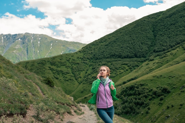 Freiheitsreisende Frau, die mit Telefon in den Händen steht und eine wundervolle Natur genießt.