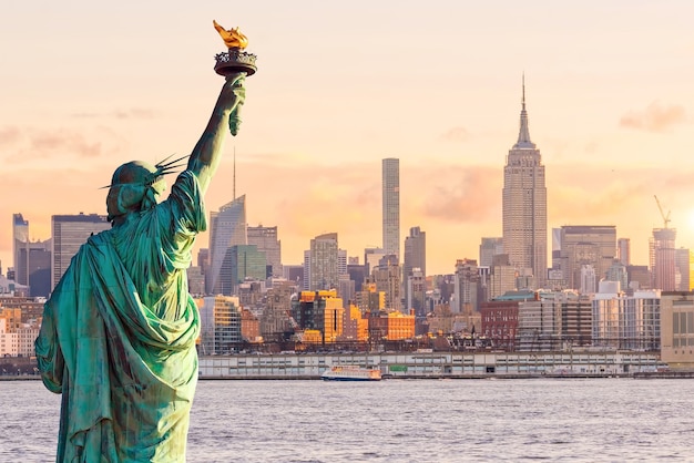 Freiheitsstatue und Skyline von New York bei Sonnenuntergang, in USA