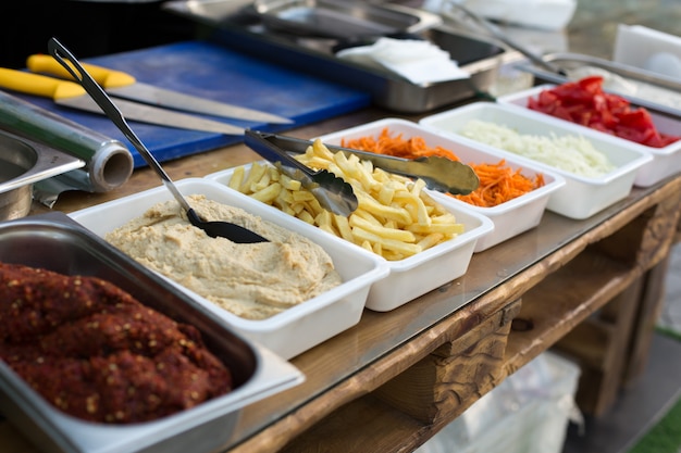 Freilichtküchenprodukte für das Kochen von Falafel in den Tellern auf einem Holztisch.