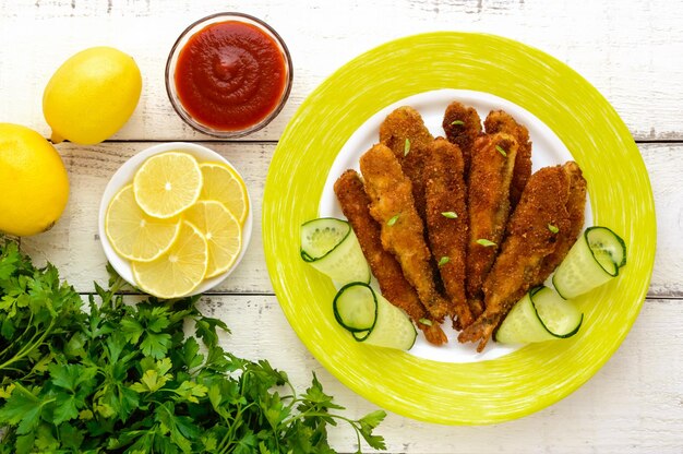 Freír capelán de pescado pequeño en un plato sobre fondo blanco de madera La vista superior