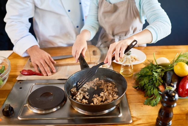 Freír champiñones en el taller de cocina