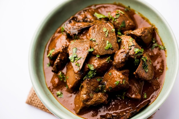 Freír de hígado de cordero o Kaleji masala, receta popular no vegetariana de India y Pakistán. servido seco o con curry en un bol, karahi o plato