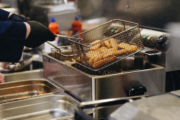 Freír nuggets de pollo en una freidora Preparación de comidas en restaurantes