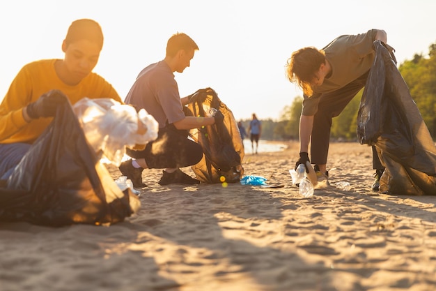 Freiwillige Aktivisten des Erdtags sammeln Müll und reinigen den Strand. Gruppe von Menschen aus der Küstenzone