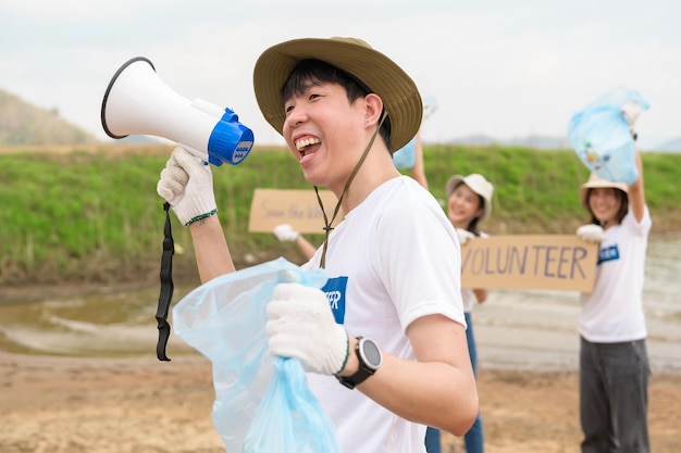 Freiwillige der asiatischen Jugendgemeinschaft säubern mit Müllsäcken die Natur par