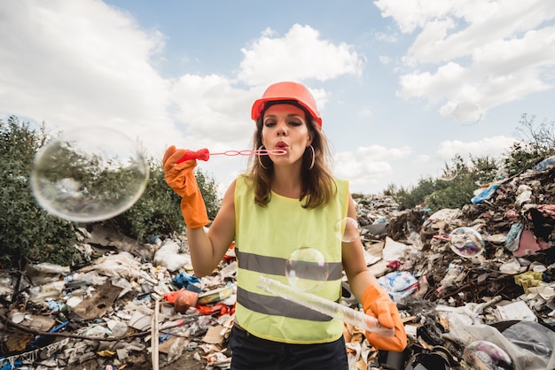 Freiwillige Frau mit Blasen hilft, das Feld von Plastikmüll zu reinigen. Tag der Erde und Ökologie.