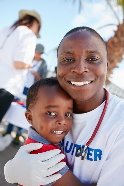 Freiwilligenarbeit aus Liebe zu Kindern Porträt eines fürsorglichen freiwilligen Arztes, der benachteiligten Kindern Vorsorgeuntersuchungen durchführt