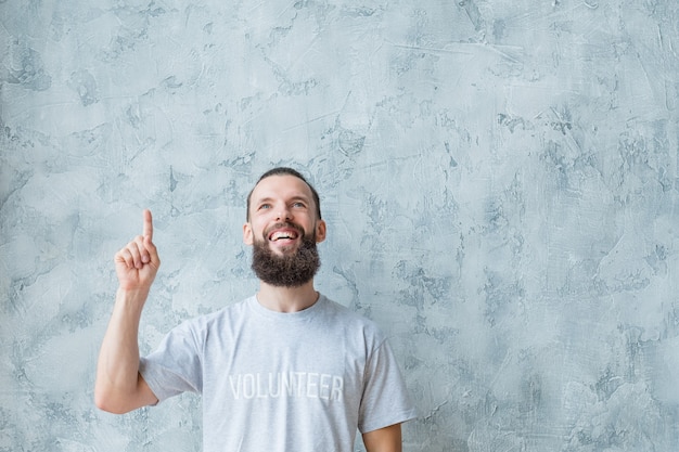 Freiwilligenarbeit. Modernes Lifestyle-Konzept. Mann im T-Shirt mit Zeigefinger nach oben.