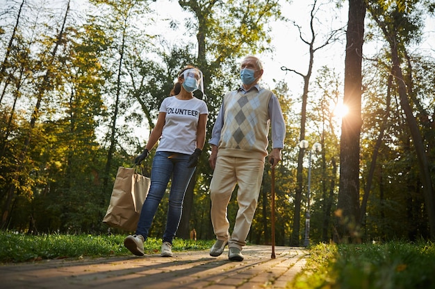 Freiwilliger Frau im Gespräch mit älterem Mann im Stadtpark