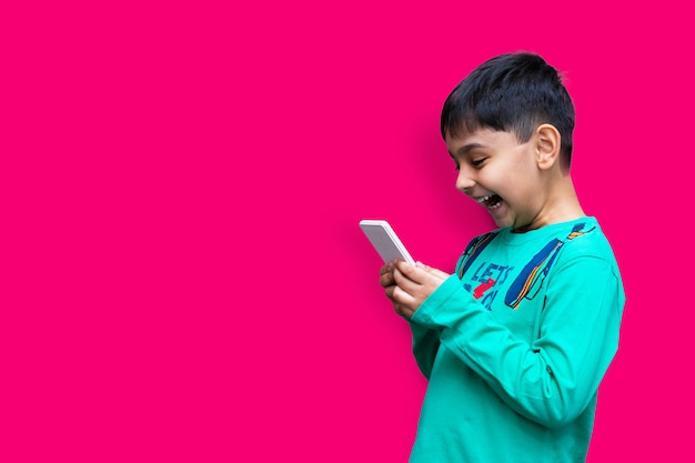 Freizeit-, Kinder-, Technologie- und Menschenkonzept - lächelnder Junge mit Smartphone oder Spiel zu Hause kopieren