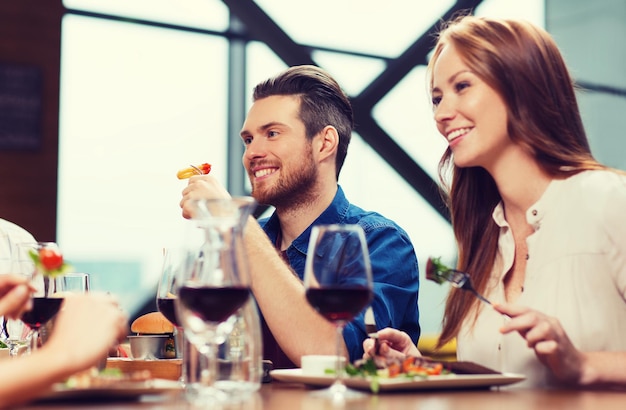 Freizeit, Speisen und Getränke, Personen- und Urlaubskonzept - glückliches Paar beim Abendessen im Restaurant