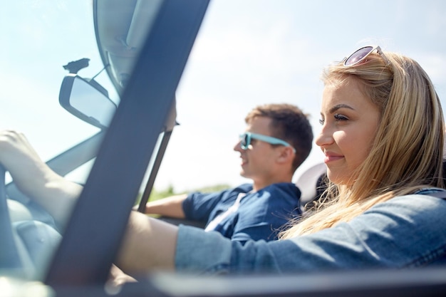 Freizeit-, Straßenreise-, Reise- und Personenkonzept - glückliches Paar, das draußen im Cabriolet-Auto fährt