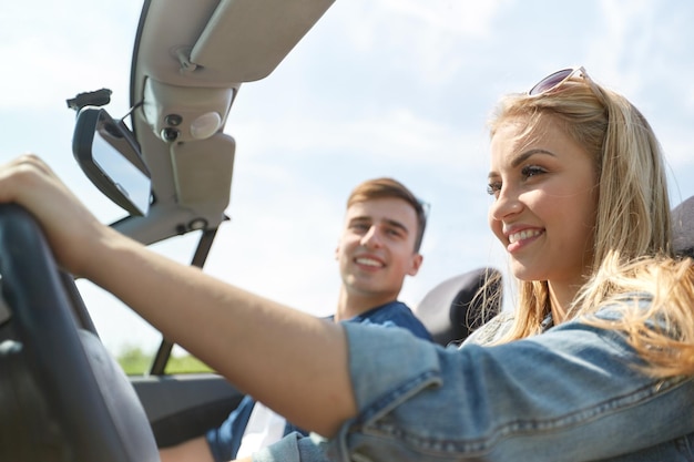 Freizeit-, Straßenreise-, Reise- und Personenkonzept - glückliches Paar, das draußen im Cabriolet-Auto fährt