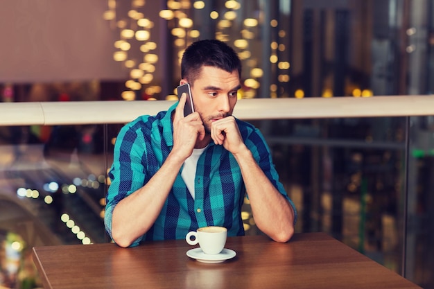 Freizeit-, Technologie-, Lifestyle- und People-Konzept - Mann mit Smartphone und Kaffee im Restaurant