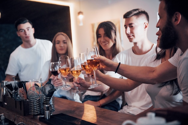 Freizeit- und Kommunikationskonzept. Gruppe von glücklich lächelnden Freunden, die Getränke genießen und an der Bar oder im Pub sprechen