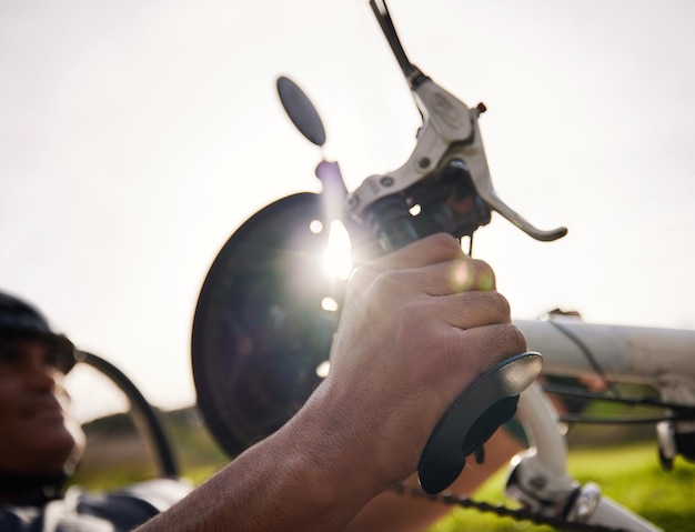 Frenar el ciclismo y las manos en una bicicleta para una persona con discapacidad para hacer ejercicio, ciclismo y entrenamiento físico en el parque Frenar la mano en el pedal o el manillar para detener lentamente o controlar la velocidad en la bicicleta