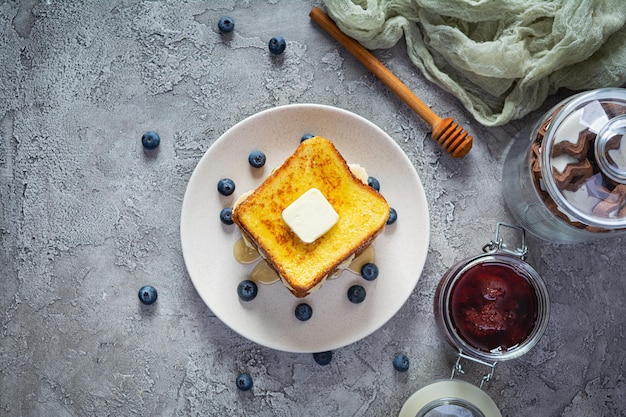 French Toast mit Banane, Blaubeere, Honig und Erdbeermarmelade. Köstliches Frühstück oder Brunch am Morgen mit Toast und Keksen. Ansicht von oben