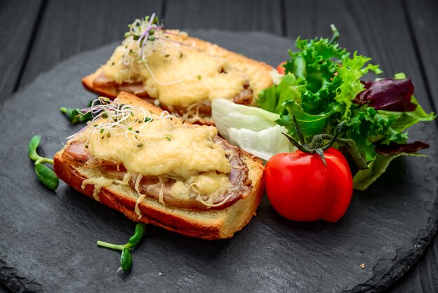 French Toast Schinken Käse und Salat auf Teller. Auf dem Holztisch