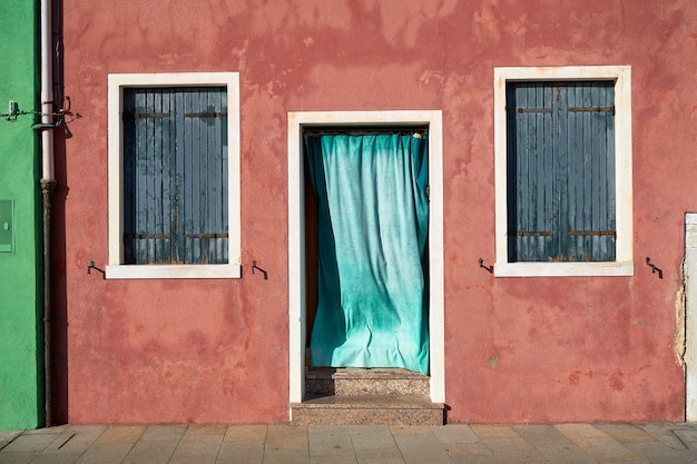 Frente da casa vermelha na ilha de Burano. Itália, Veneza