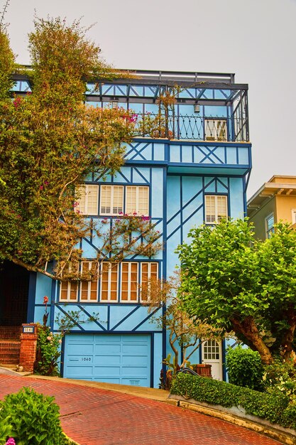 Frente a la impresionante casa azul de la costa oeste en el camino de ladrillos rojos de Lombard Street