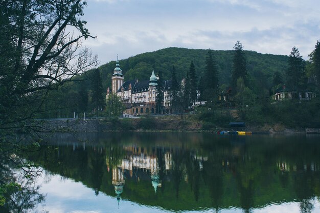 Frente norte del palacio de Lillafured en Miskolc Hungría Lago Hamori en primer plano con reflejos Fondo histórico de viajes al aire libre