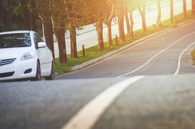 Frente de nuevo aparcamiento de coches blancos en la carretera de asfalto