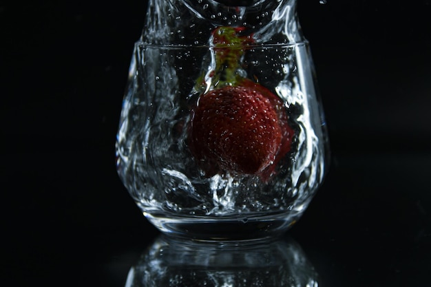 Una fresa en agua con un chorrito de agua