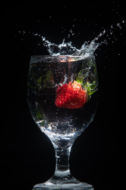 La fresa cae en un vaso de agua.