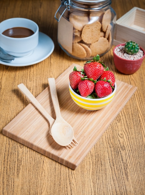 Fresa fresca y jugo en la mesa de madera. piso plano.