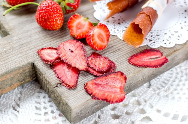 Foto fresa jugosa madura, fruta seca, chips y pastillas de fresas.