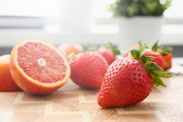 Fresa y naranja roja en la mesa de la cocina