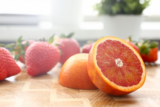 Fresa y naranja roja en la mesa de la cocina