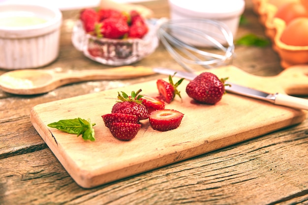 Fresa en tabla de cortar. Ingredientes crudos para cocinar pastel de fresa