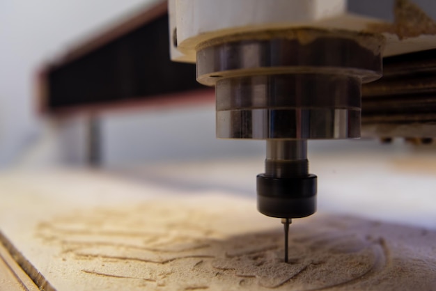 Foto fresado de madera en una moderna máquina automática de carpintería con cnc. producción de muebles.