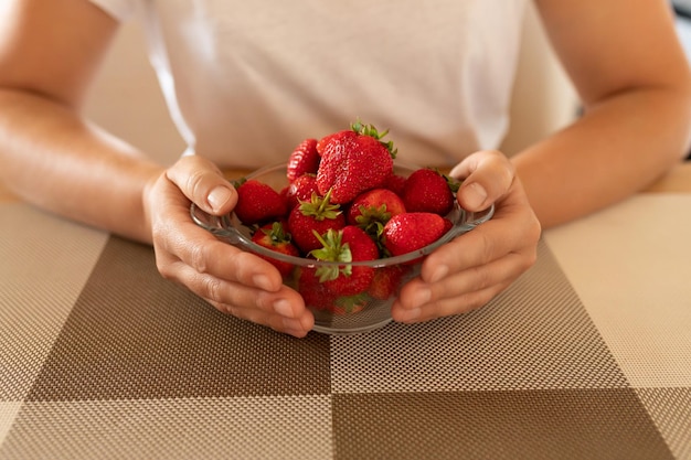 Fresas aromáticas en un primer plano de manos de mujer