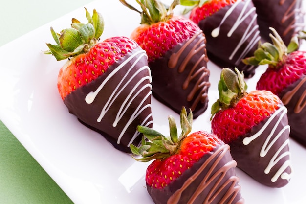 Fresas bañadas en chocolate en la barra de postres.