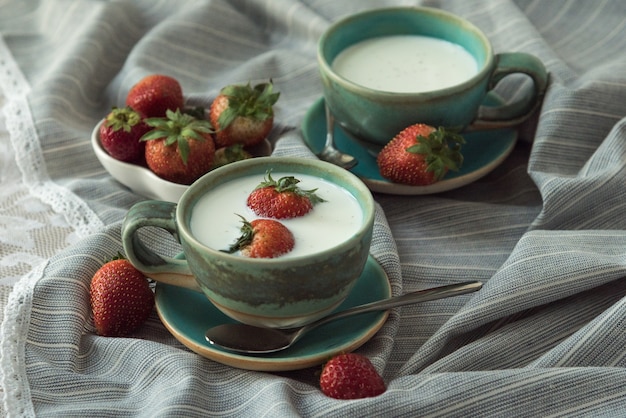 Fresas y bebidas de leche sobre fondo de tela