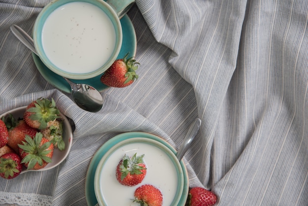 Foto fresas y bebidas de leche sobre fondo de tela